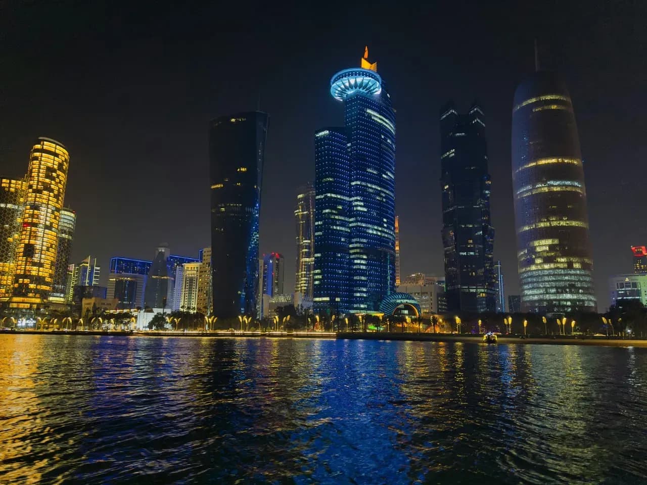 Небоскрёбы Дохи ночью с подсветкой, морской набережной и атмосферой футуристичного Катара.