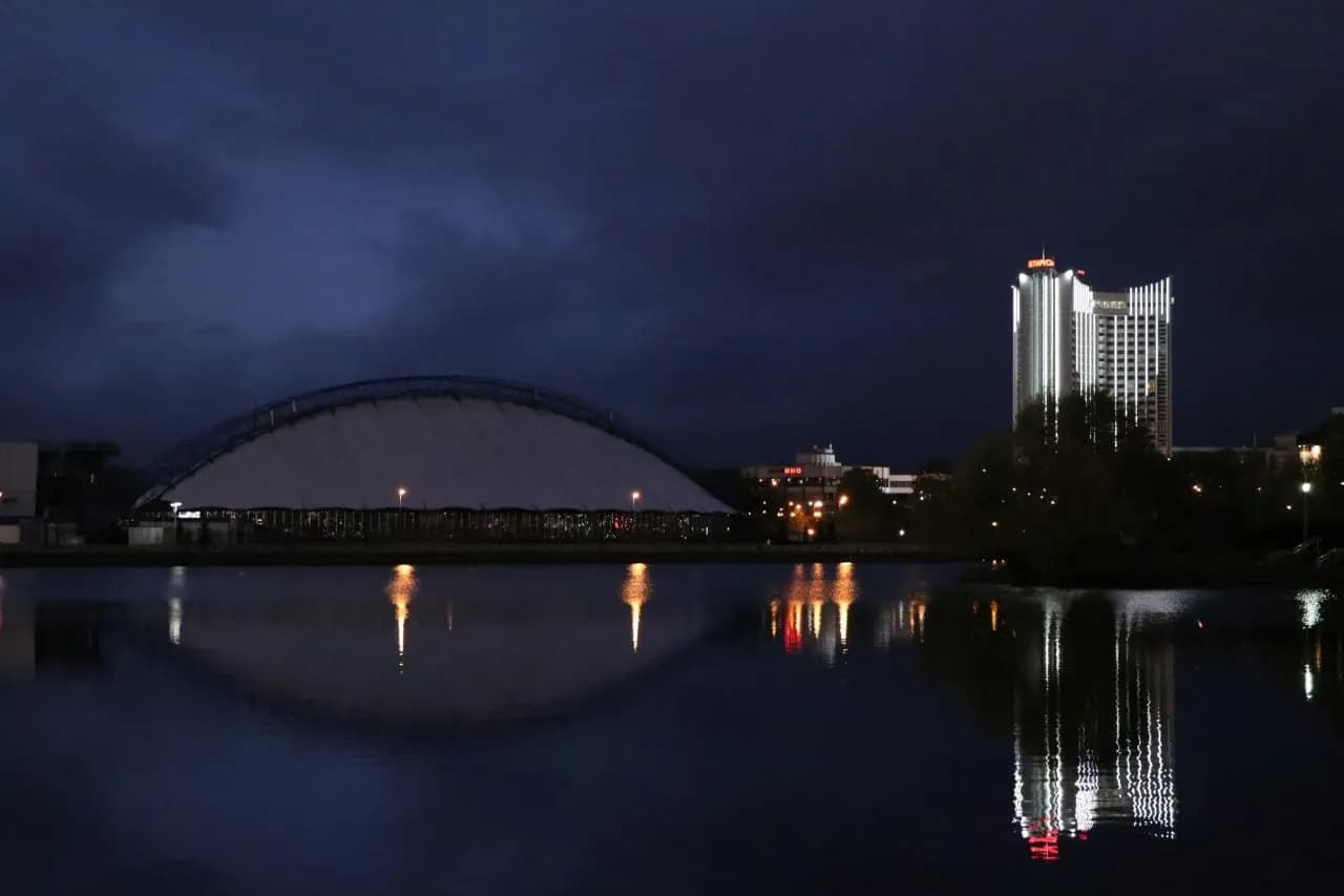 Ночной Брест с подсвеченным мостом, рекой и отражением городских огней в воде.