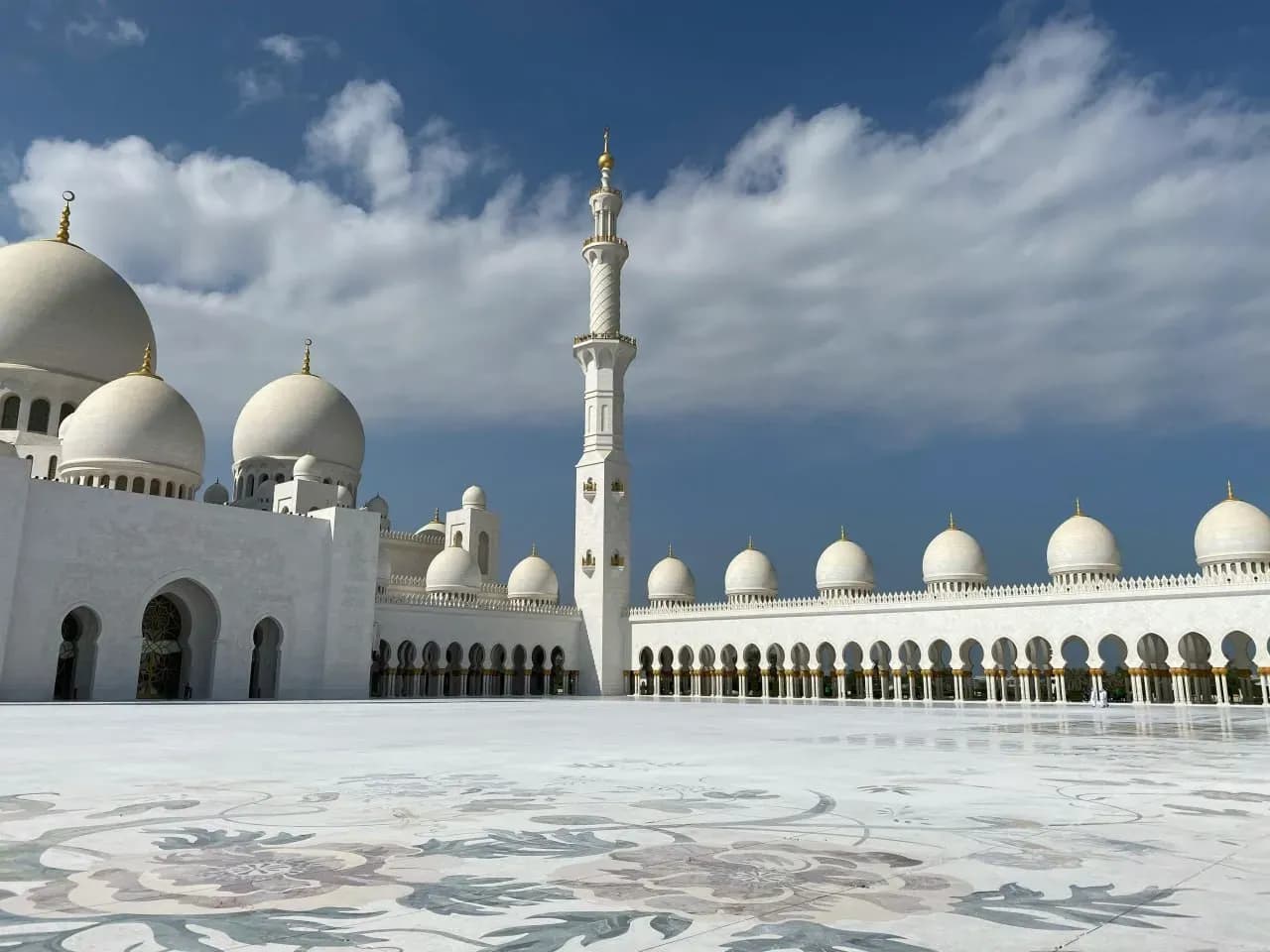 Белоснежная мечеть шейха Зайда в Абу-Даби с куполами, минаретами и мраморной площадью.