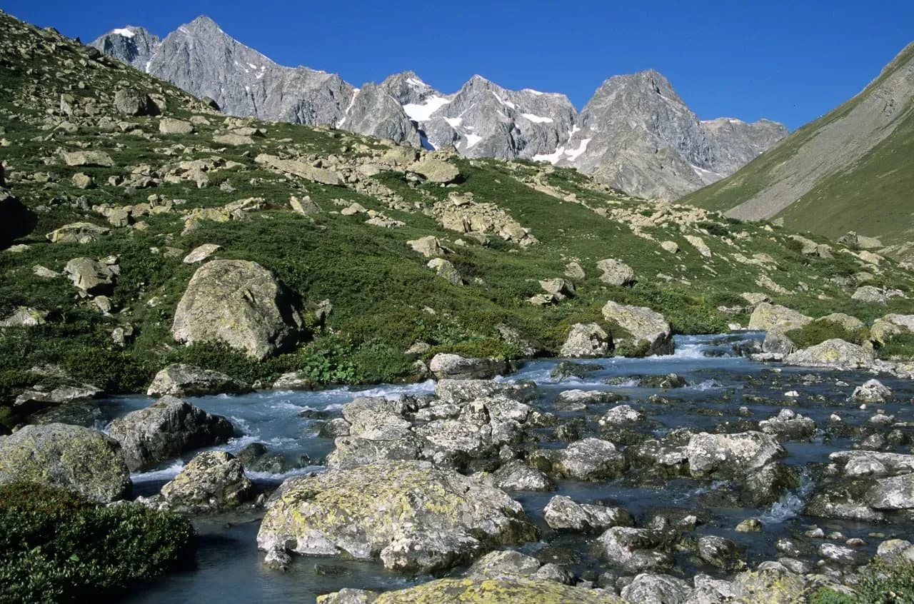 Горная река в окрестностях Алматы среди камней, чистой воды и кавказских пейзажей Заилийского Алатау.