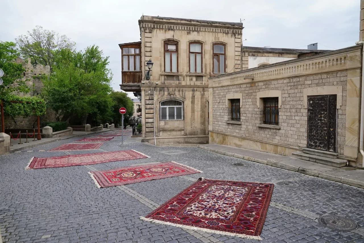 Старинная улица Бухары с коврами, каменной мостовой, историческими фасадами и атмосферой восточного города-лабиринта.