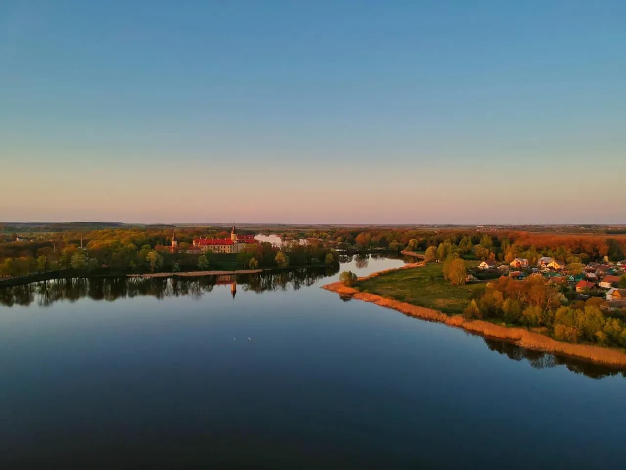 Озёрный берег с камышами и спокойной водой для рыбалки и отдыха на природе.