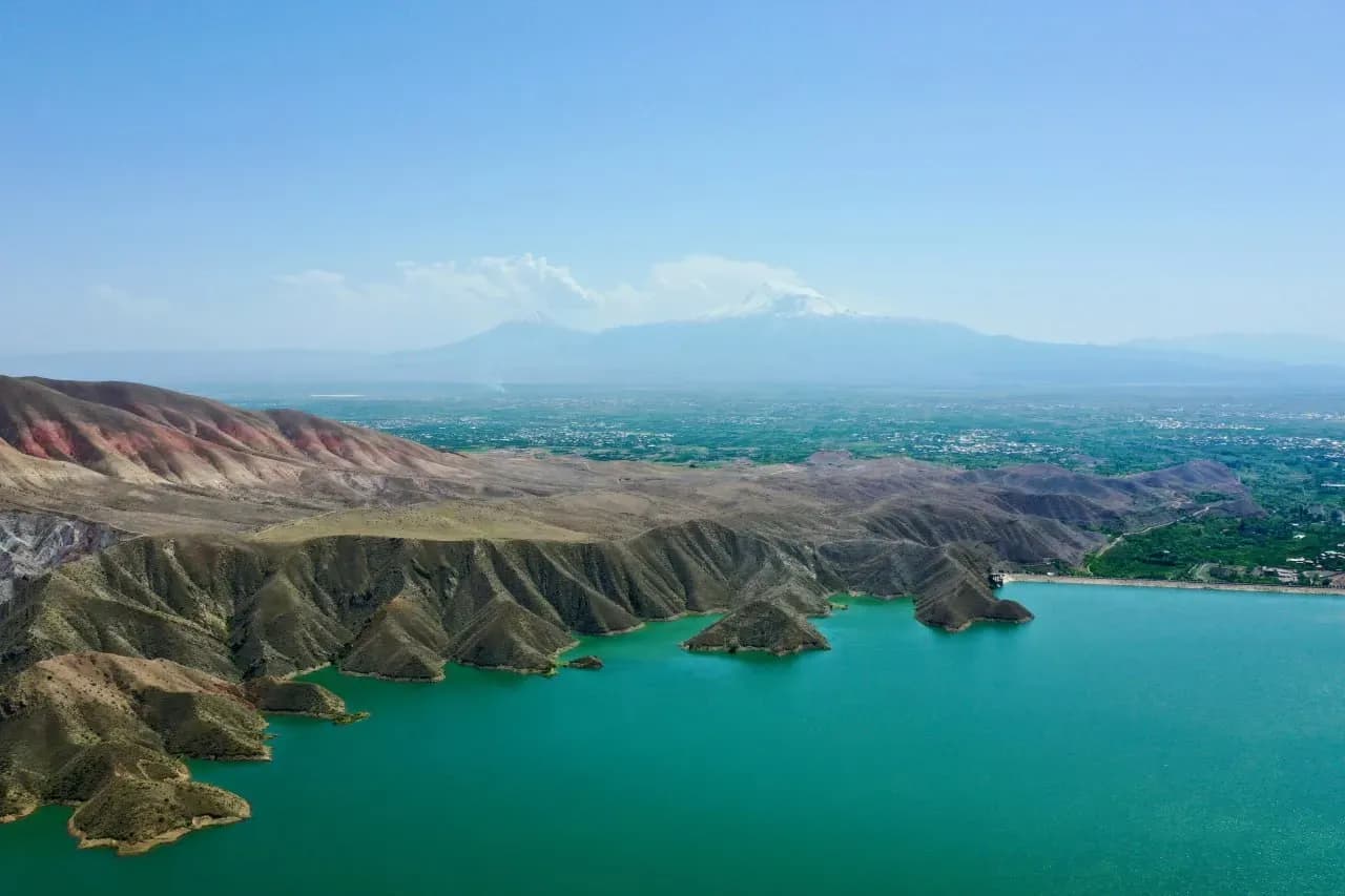Кипарисовое озеро в Сукко рядом с Анапой с деревьями в воде, прозрачной гладью и горным пейзажем.