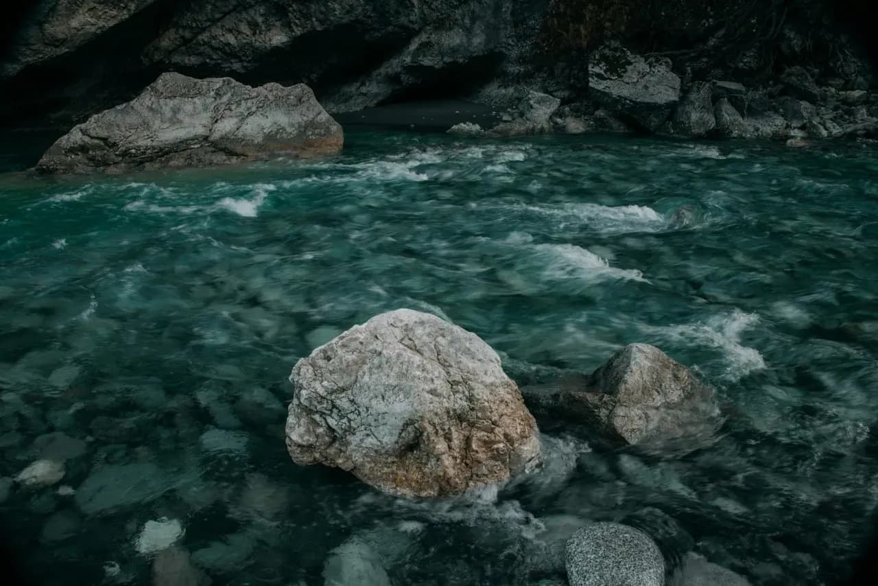 Бурная горная река в Дагестане с камнями, тёмной водой и атмосферой кавказского ущелья.