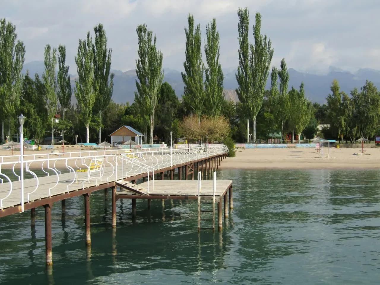 Деревянный пирс у Красного моря с прозрачной водой и спокойной атмосферой для пляжного отдыха.