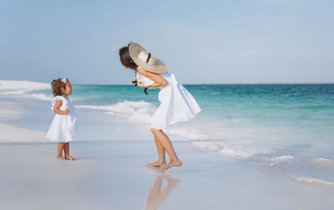 Мама с дочкой играют на пляже