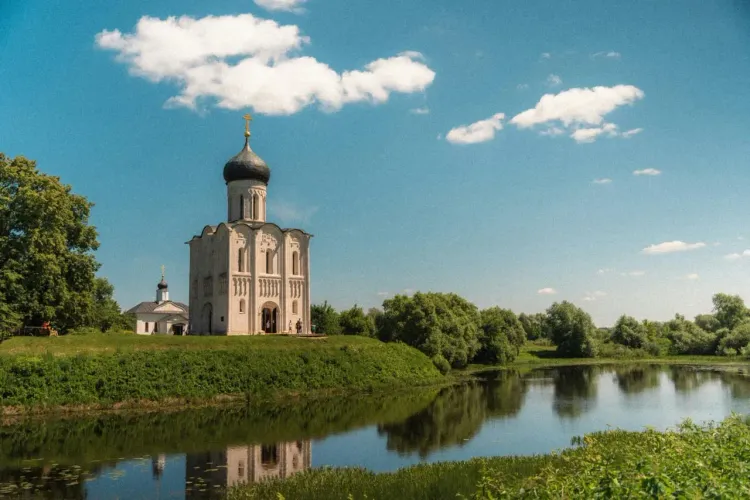 Старинный храм в окрестностях Гродно среди зелёного луга, деревьев и исторической белорусской архитектуры.
