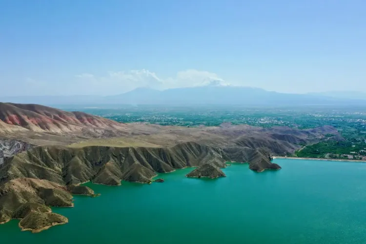 Кипарисовое озеро в Сукко рядом с Анапой с деревьями в воде, прозрачной гладью и горным пейзажем.