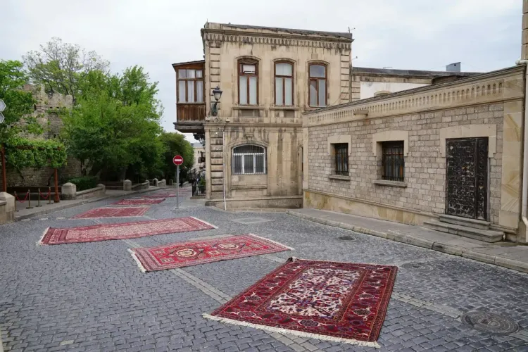 Старинная улица Бухары с коврами, каменной мостовой, историческими фасадами и атмосферой восточного города-лабиринта.